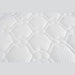 Close-up of the King Koil Paradise Mattress surface, featuring a soft, padded white fabric with a quilted hexagon and circle pattern. Flex-edge border supports and detailed stitching enhance comfort, support, and varied texture.