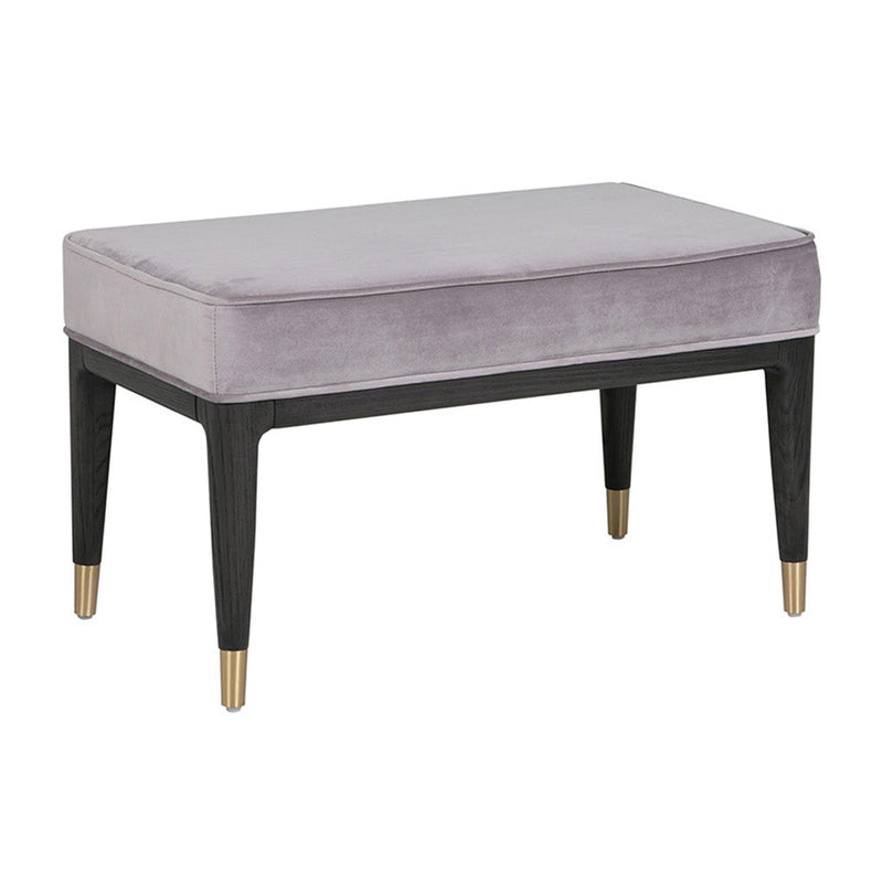 A gray velvet dressing stool with a cushioned top and black wooden legs with gold accents.