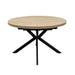 The Dalton 1.2 Round Extending Table features a light wood finish, a central split for extension, and intersecting black metal legs, set against a plain white background.
