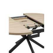 A close-up of the Dalton Table + 4 Lyra Chairs set reveals its modern light wood tabletop and black metal legs, showcasing the extendable mechanism and interior hardware as the table is partially open.