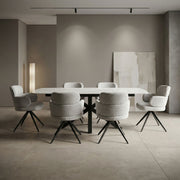 A minimalist dining room showcases the Positano Table with six Orbit Chairs in grey upholstery and black legs, complemented by neutral walls, soft lighting, and abstract artwork for an elegant, serene ambiance.