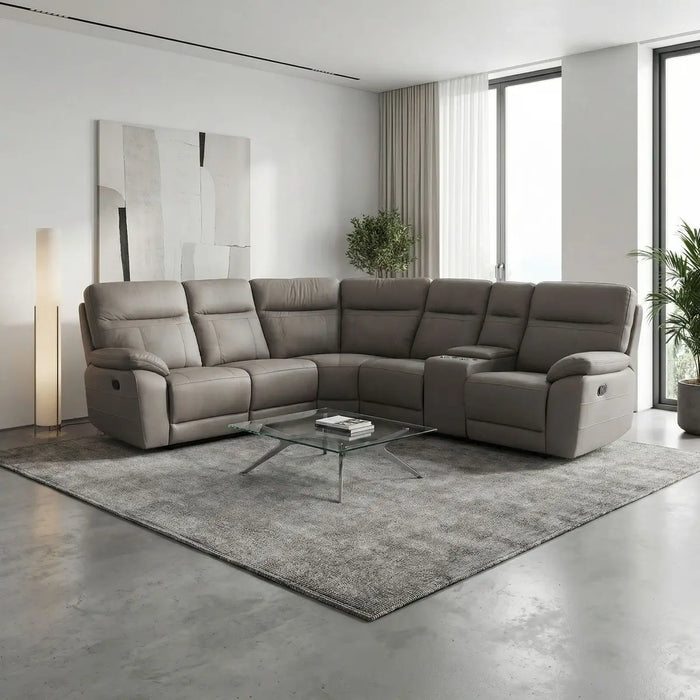 A modern living room with the Jude Corner Sofa in gray, a glass coffee table, gray area rug, abstract wall art, floor lamp, and large windows with sheer curtains letting in natural light.
