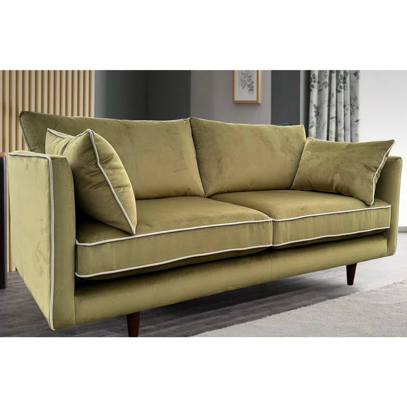 The Hugo sofa, a modern olive green velvet piece with white piping, features two seat and back cushions, two side pillows, wooden legs, and is crafted from durable Aquaclean fabric for easy maintenance.