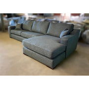 The Alice Range is a modern gray sectional sofa with square arms, three seat cushions, a wide chaise lounge, and two matching throw pillows—perfect as stylish living room furniture.