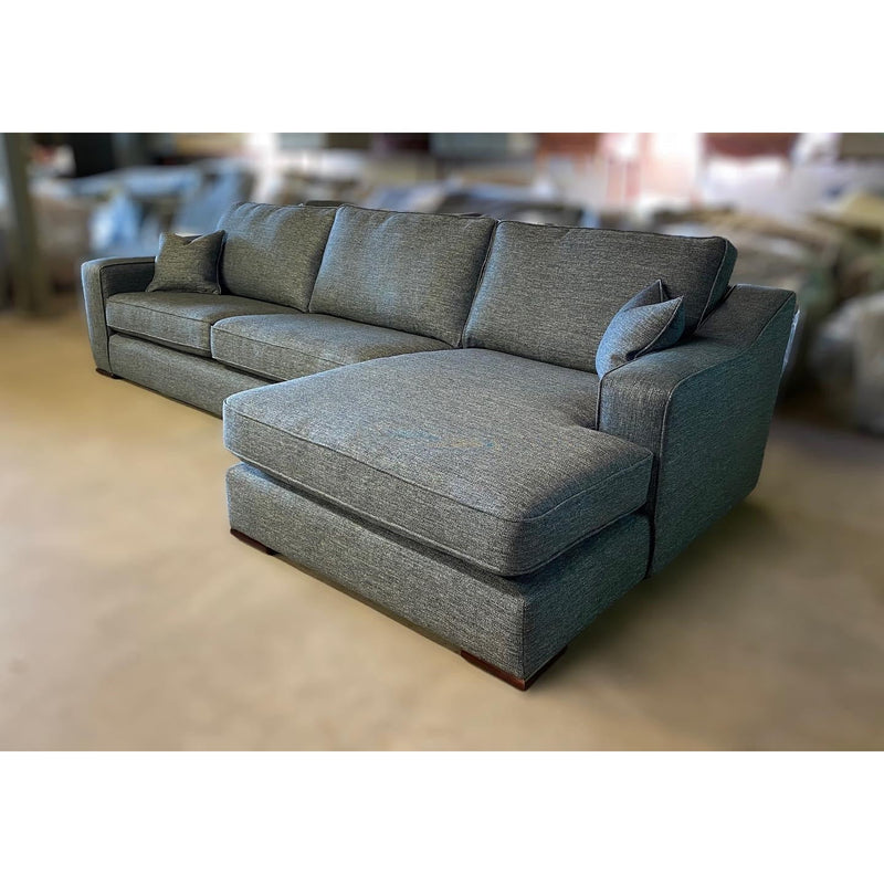 The Alice Range is a modern gray sectional sofa with square arms, three seat cushions, a wide chaise lounge, and two matching throw pillows—perfect as stylish living room furniture.