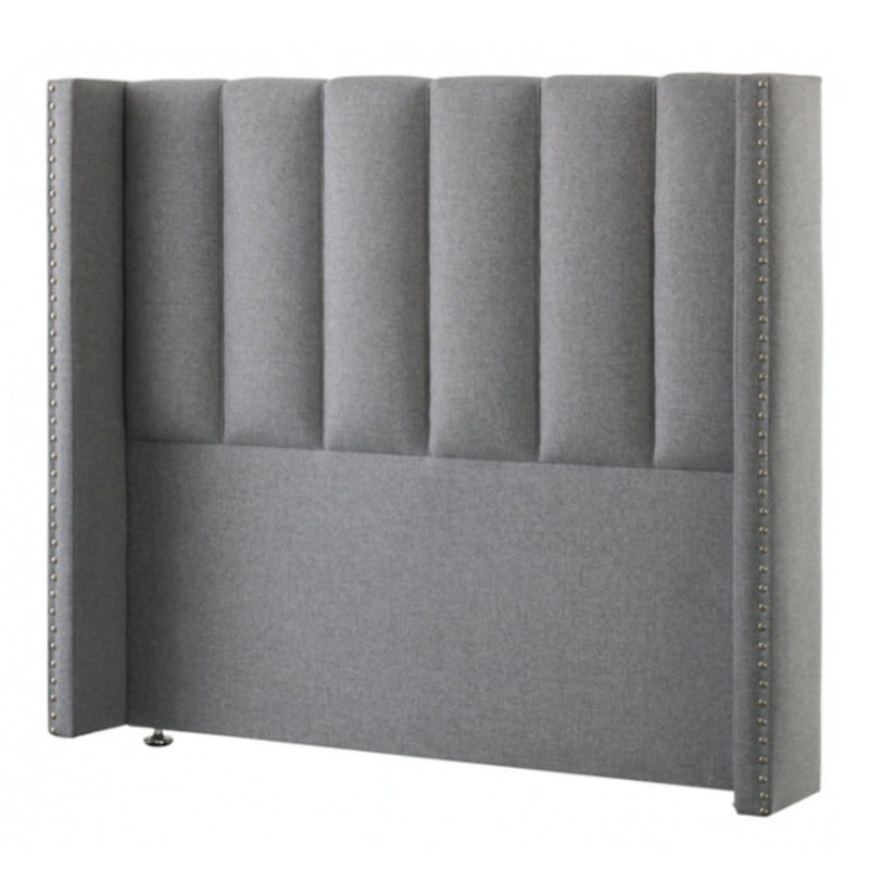 A gray upholstered Respa Janus headboard with a solid pattern, featuring wings and individual chrome studs.