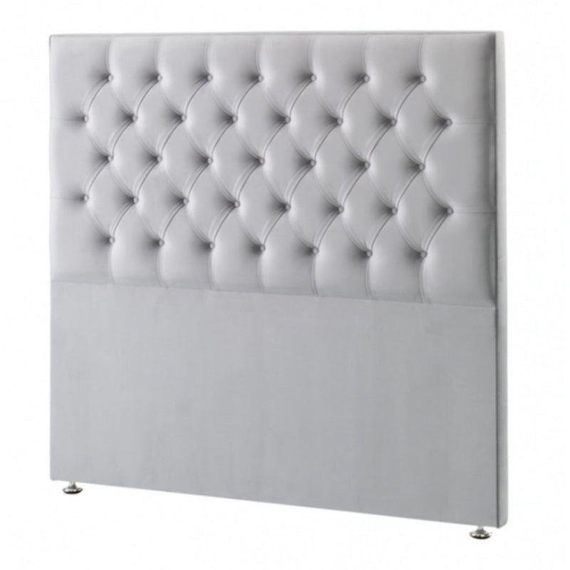 A modern white leather headboard with a button tufted design.