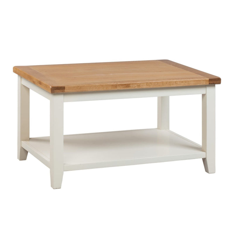 A rectangular Skellig coffee table with a cream painted base and natural oak tabletop, featuring a lower shelf.