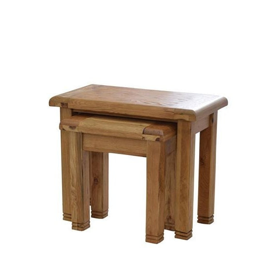A weathered oak finish nesting table with a slightly rough texture, featuring a rectangular top and three sturdy legs.