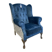 The Queen Anne Chair features blue velvet upholstery, button-tufted detailing, floral patchwork fabric sides, curved armrests, and dark wooden cabriole legs. Expertly made in Ireland and displayed against a white background.