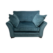 A blue upholstered armchair with two pillows, set against a white background.