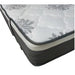 A mattress with white and gray fabric on a single mattress set.