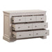 The Lima Wide Chest, a light gray wooden dresser from the Taupe Bedroom Range, features nine roomy drawers with round knobs and a sturdy build, shown partially open against a white background.
