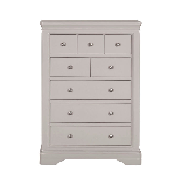 The Lima Tall Chest, in light gray with a modern design, features seven drawers of varying sizes, each with a round silver knob—an ideal addition to any taupe bedroom collection.