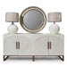 The Marvel Sideboard features modern fluted doors with vertical grooves and gold handles, topped with two plastic-wrapped white lamps and a large round silver-framed mirror centered above.