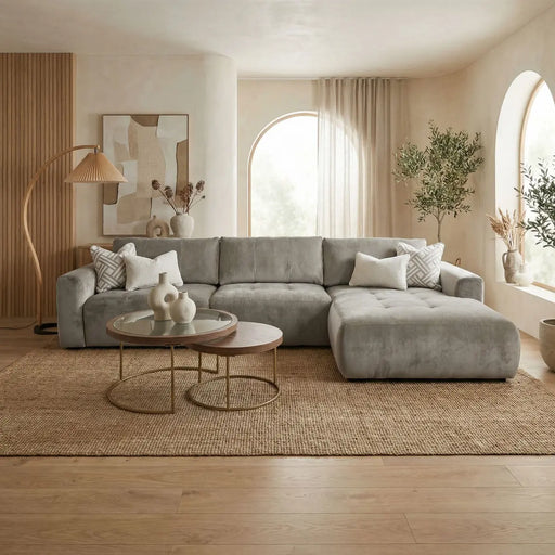 A modern living room featuring the Opus Chaise in Aquaclean fabric, round nesting coffee tables, neutral decor, large arched windows with sheer curtains, indoor plants, a jute rug, and wood accents for natural texture.