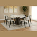 A round dining table with a dark conical base is paired with six Titan Dining Chairs in light gray stone fabric on a textured rug. Abstract artwork and a tall potted plant accent the neutral-toned room.