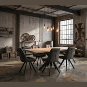 A modern industrial-style meeting room featuring the Dalton 160cm Ext Table & 6 Pedro Chairs, with exposed brick walls, large windows, pendant lights, metal shelves, decorative gears, and a potted plant.