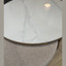 A close-up of two overlapping round Vienna Coffee Table + Footstool pieces: the coffee table features a glossy white marble top with gray veining, while the footstool below has a light gray textured fabric surface.