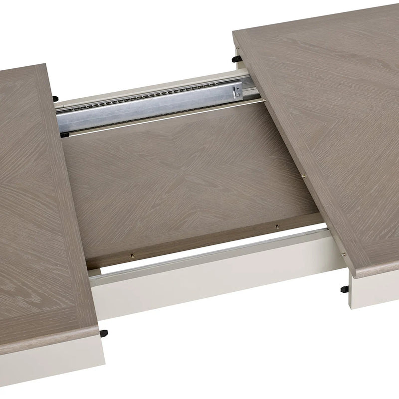 A close-up of the Montreux Dining Table in grey washed oak, featuring its middle leaf partially extended and showcasing the sliding metal extension mechanism.