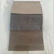 A fabric swatch card labeled REMIND BASE AND HEADBOARD shows three rectangular samples—ideal for selecting upholstery for the Hilton Storage Bedframe—pinned to a white card on a textured white background.