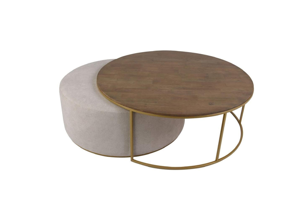 The Todi Round Coffee Table & Stool Set features a round wooden tabletop on a gold metal frame with a matching light beige upholstered ottoman, both with gold bases, ideal for modern interiors and styled against a white background.