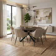 A modern dining room featuring the Olson 1.5 Round Dining Table for six, beige upholstered chairs, a woven rug, abstract wall art, a potted plant, sheer curtains, and large windows that fill the space with natural light.