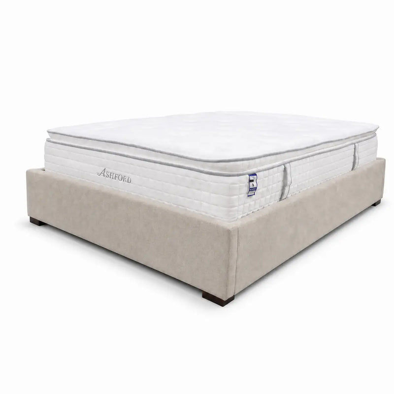 A beige upholstered bed frame holds a thick, white Ashford Pillowtop Mattress with cooling gel memory foam and a quilted surface, set against a plain white background.