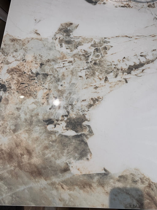 The Sorrento Dining Table features a marble effect with brown, beige, and gray veining on a white background, creating an abstract natural stone look.