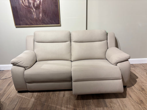 The Lorenzo Electric Recliner, in modern beige with one footrest extended, sits on a wooden floor against a light gray wall. Above the left side hangs a large painting featuring dark purple tones.