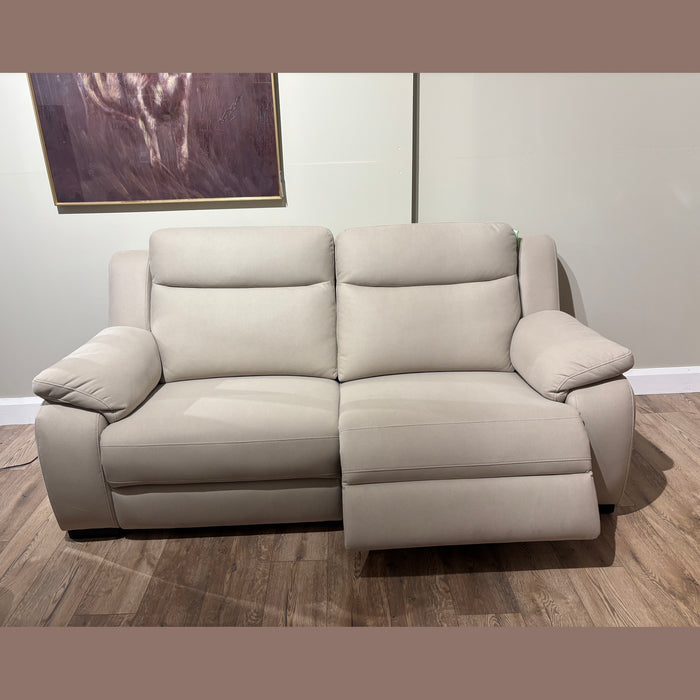 The Lorenzo Electric Recliner Sofa in modern beige features plush armrests, two seat cushions (one fully reclined with extended footrest), washable fabric, and sits on a wood floor below a framed abstract painting.