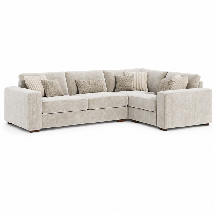 The Henley is a light beige contemporary L-shaped sofa in soft chenille fabric with clean lines, five patterned throw pillows, and wooden block feet, shown against a plain white background.