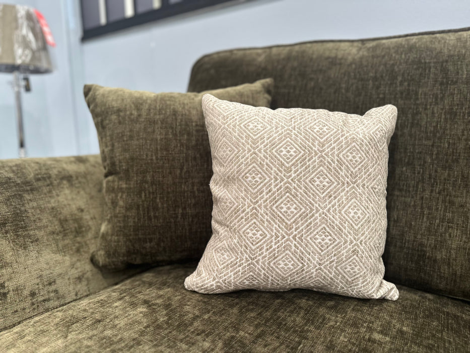 A dark green Cosmos Sofa featuring two cushions—one solid dark green and one light beige with a geometric pattern—placed side by side against the backrest for a comfortable, stylish look.
