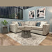 A cozy living room featuring the Ivy Corner Sofa in premium beige fabric, adorned with blue and patterned cushions, two round wooden tables, a potted plant, abstract wall art, and a patterned rug on wooden flooring.