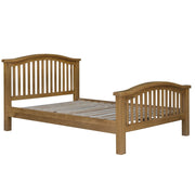 The Saoirse Bedframe is a wooden bed frame with a natural finish, curved headboard and footboard, slatted details, and sturdy square legs. Timeless bedroom furniture; mattress and bedding not included.
