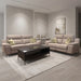 A modern living room featuring the Chloe 3+2 Electric Recliner Sofa with beige seating, green and cream geometric pillows, a dark wood coffee table with a tray, a light area rug, minimalist decor, and neutral-toned abstract wall art.