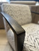 Close-up of the Falcon Accent Chair, showcasing its contemporary design with black wooden armrests and light-patterned upholstery, while identical Falcon Accent Chairs appear softly blurred in the background.