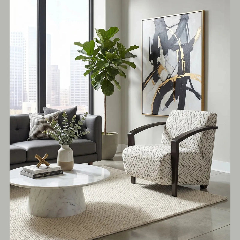 Modern living room with large windows, a gray sofa, patterned armchair, marble coffee table, potted plant, abstract wall art, and a neutral rug on a polished floor. The space is elevated by the Falcon Accent Chair, which adds both comfort and style.
