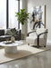 Modern living room with large windows, a gray sofa, patterned armchair, marble coffee table, potted plant, abstract wall art, and a neutral rug on a polished floor. The space is elevated by the Falcon Accent Chair, which adds both comfort and style.
