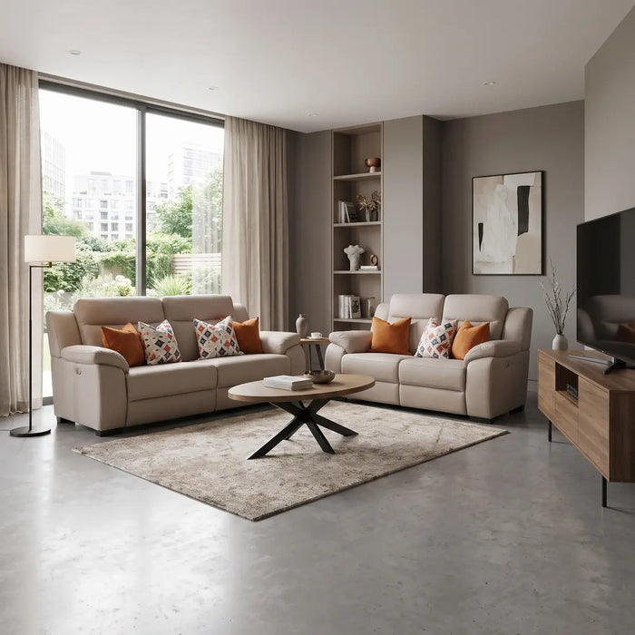 Contemporary living room featuring a Lorenzo Electric Recliner 3 seater sofa in washable fabric, paired with a beige two-seater, patterned and orange cushions, a round coffee table on a rug, floor lamp, built-in shelves, wall art, TV on a wooden stand, large window with curtains, and greenery outside.