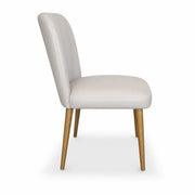 A side view of the Mia Dining Chair, featuring light beige upholstery, a cushioned seat and backrest, and four solid oak legs. The chair showcases a minimalist, contemporary design.