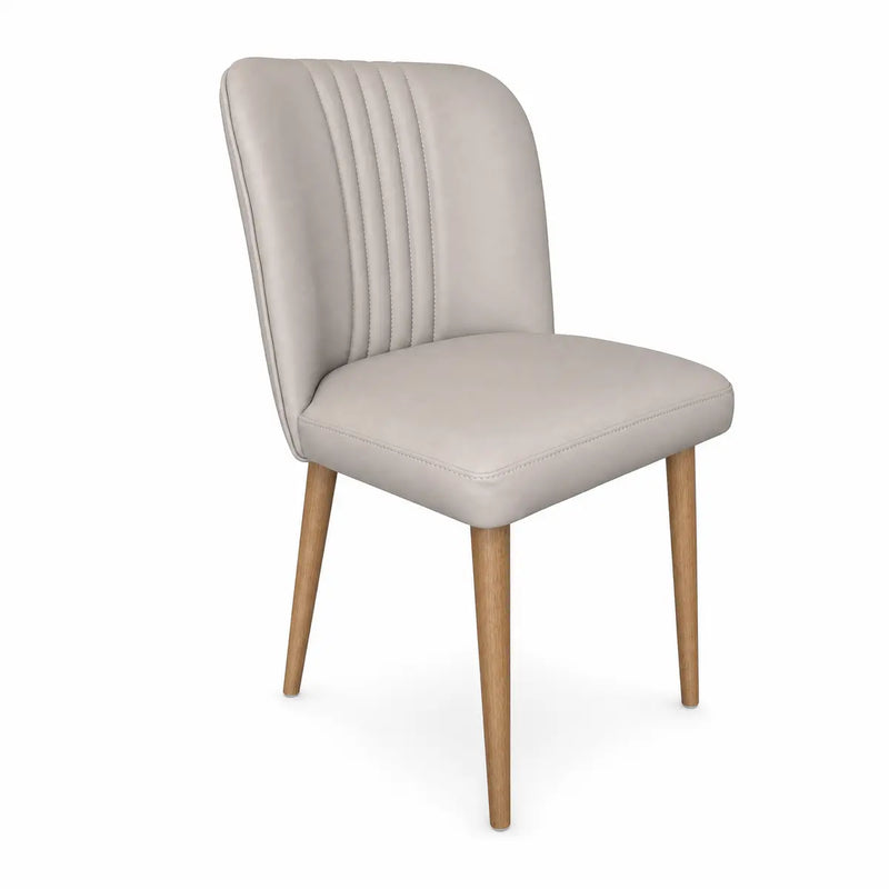 The Mia Dining Chair features light beige upholstery with vertical stitching on the backrest and four solid oak legs, shown against a white background.