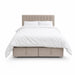 The Bella Ottoman Bed, featuring beige upholstery, a tall tufted headboard, and ample storage, is pictured with white bedding—including pillows and a duvet—against a plain white background, making it a stylish addition to your bedroom furniture collection.