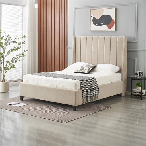A modern bedroom featuring the Oscar Bedframe in beige, white bedding, a black-and-white throw, gray rug, nightstand with books and a clock, a leafy plant, and abstract wall art above the bed.