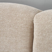 Close-up of the Oscar Bedframe’s beige, textured fabric upholstery highlights its curved backrest and softly cushioned surface. The woven appearance enhances comfort and elegance for this contemporary upholstered bed.