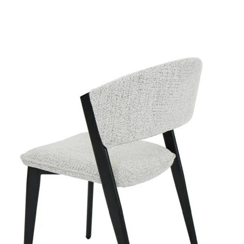 The Titan Dining Chair features a light gray stone fabric seat and backrest, black angled wooden legs, and a minimalist design—ideal for modern interiors. Shown against a plain white background.