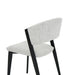 The Titan Dining Chair features a light gray stone fabric seat and backrest, black angled wooden legs, and a minimalist design—ideal for modern interiors. Shown against a plain white background.