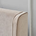 Close-up of the corner of the Rivera Storage Bedframe, upholstered in beige linen with textured fabric and piping detail, set against a light gray wall with white trim.