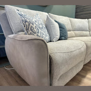 A close-up of the Willow Corner, featuring easy-clean upholstery and adorned with decorative pillows in assorted blue and gray patterns, set atop a wooden floor in a modern living room.