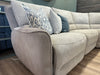 A close-up of the Willow Corner, featuring easy-clean upholstery and adorned with decorative pillows in assorted blue and gray patterns, set atop a wooden floor in a modern living room.